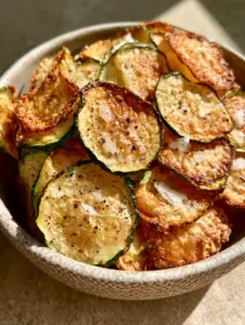 Extreme macro close-up of paper-thin Baked Zucchini Chips showing translucent edges and air bubbles.